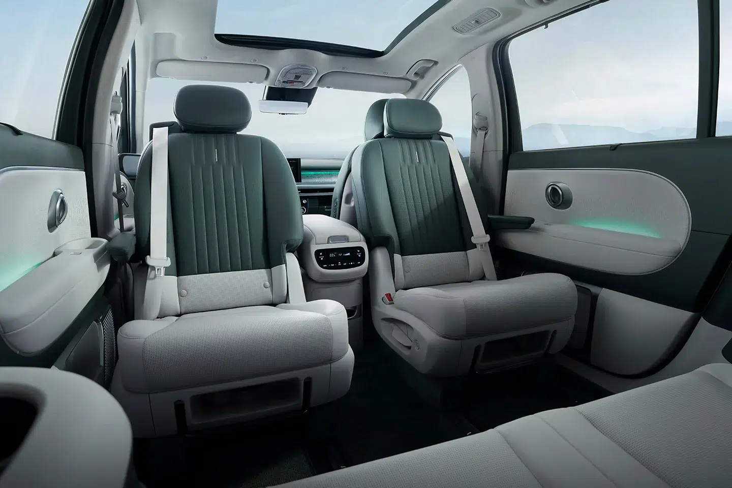 Interior of the Hyundai Ioniq 9 showing two second-row swivel captain’s chairs with ambient lighting, panoramic roof, and spacious three-row electric SUV cabin.