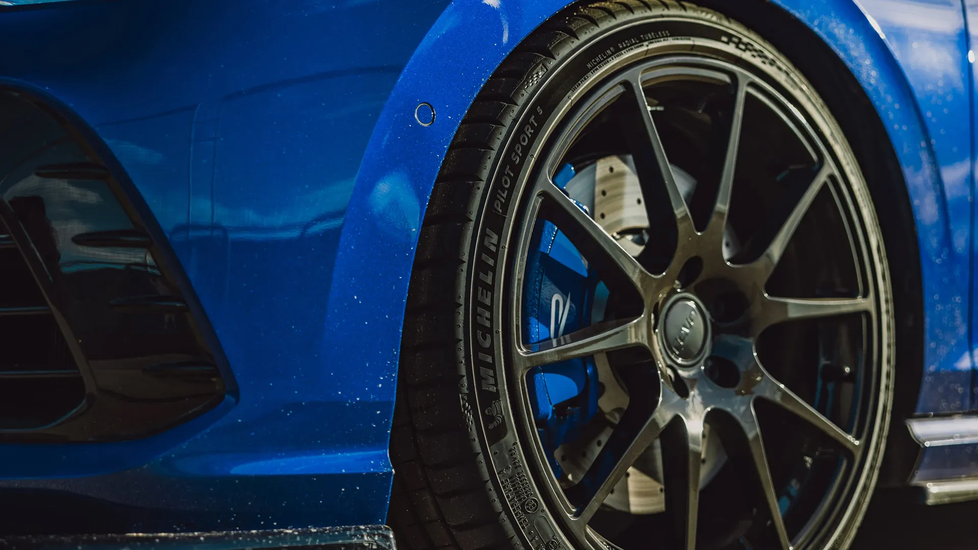 Close-up of Michelin Pilot Sport performance tyre and alloy wheel showing tread and braking components