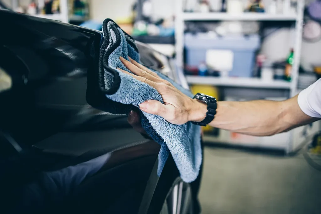 using a microfiber towel to dry car paint after washing