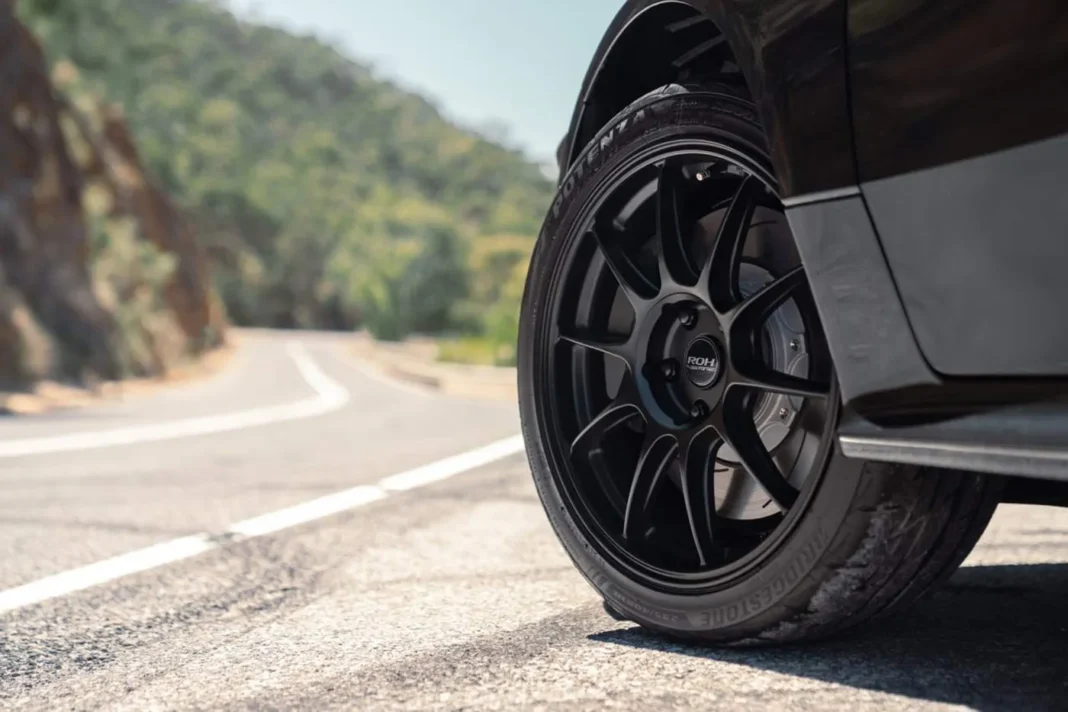 Close-up of performance tyre on alloy wheel parked on a winding road, highlighting grip and handling for Australian driving conditions