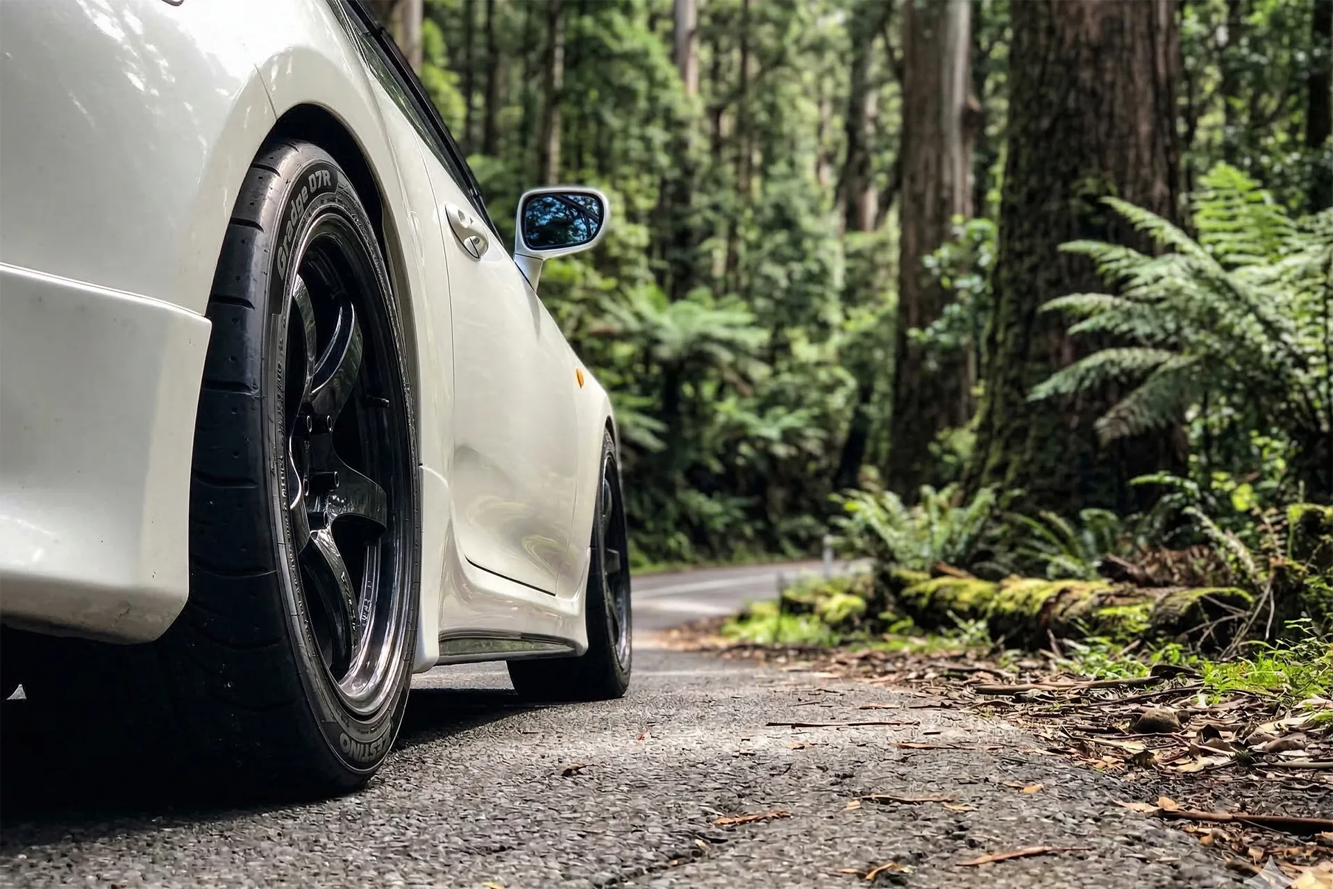 Close-up of performance car tyre tread on asphalt, highlighting vehicle preparation for mountain driving roads