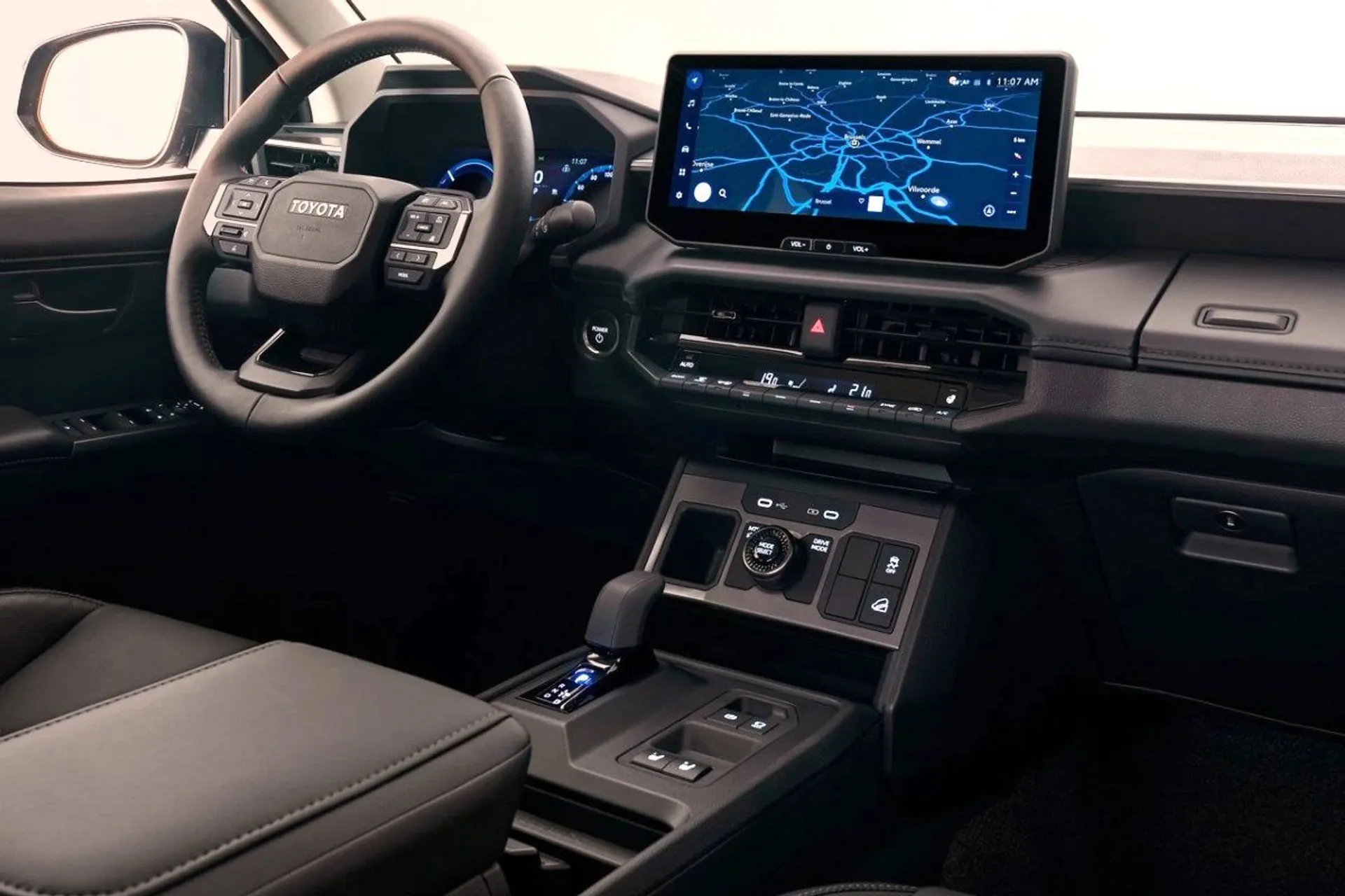 Interior dashboard of the Toyota Hilux BEV electric pickup truck showing steering wheel, digital instrument cluster, and infotainment navigation screen.
