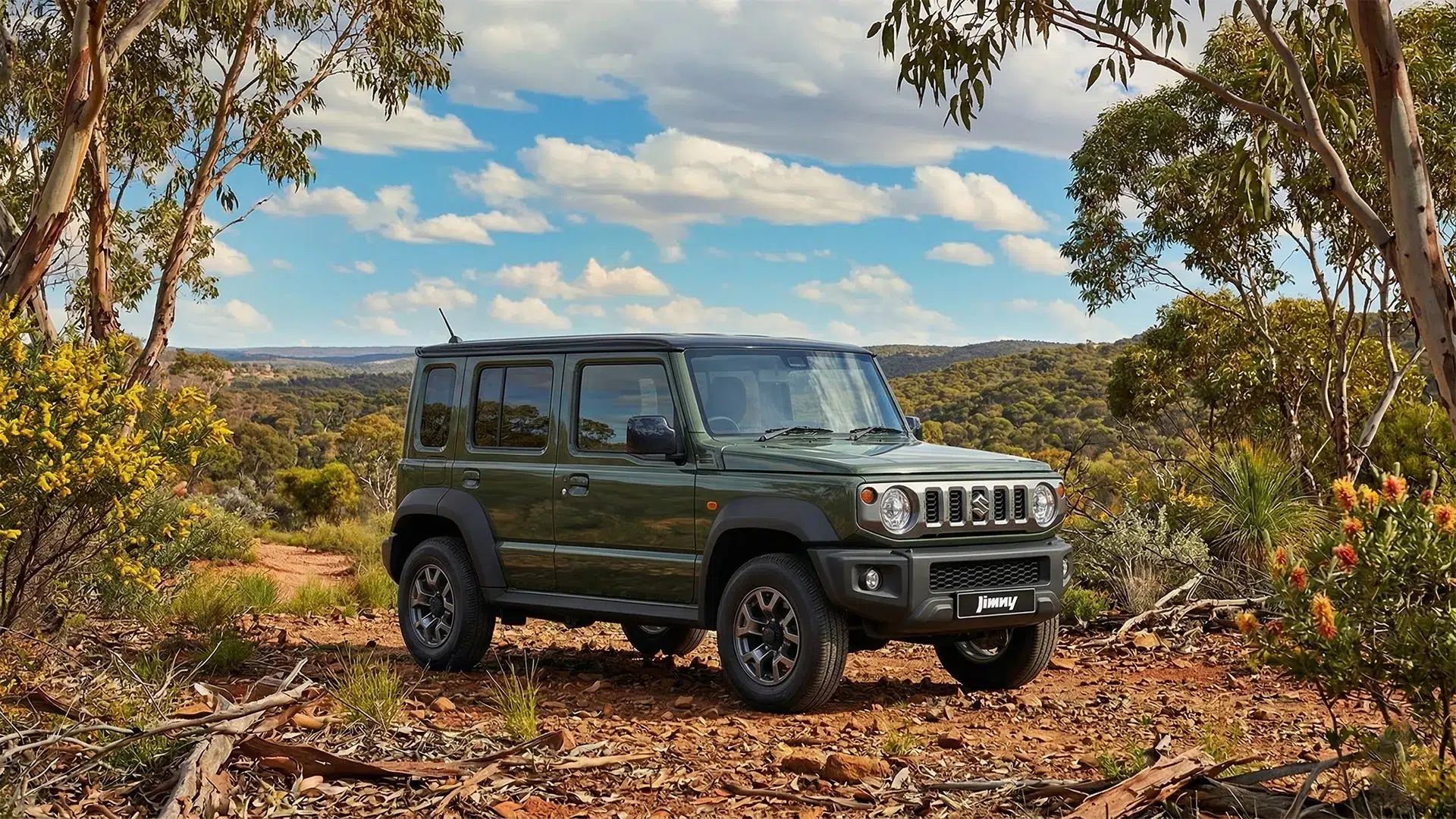 2026-suzuki-jimny-5-door-australia-review-jungle-green 2026 Suzuki Jimny 5-door in Jungle Green parked on a red dirt track surrounded by Australian bush and eucalyptus trees