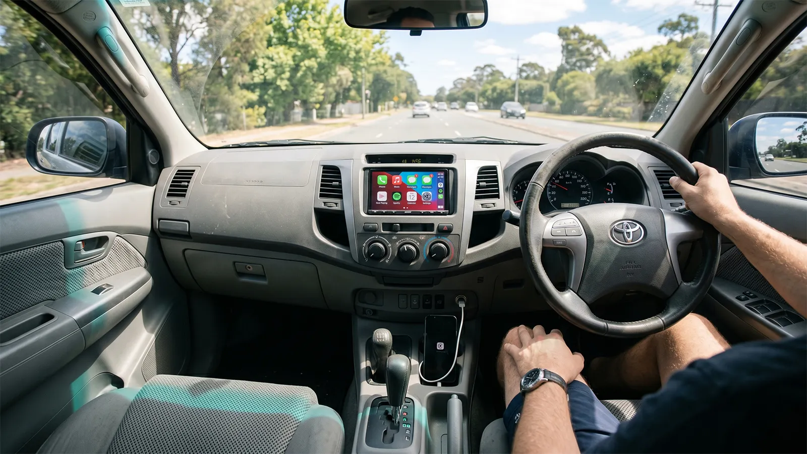 Driver perspective of Toyota HiLux interior with aftermarket Apple CarPlay head unit installed in centre dash