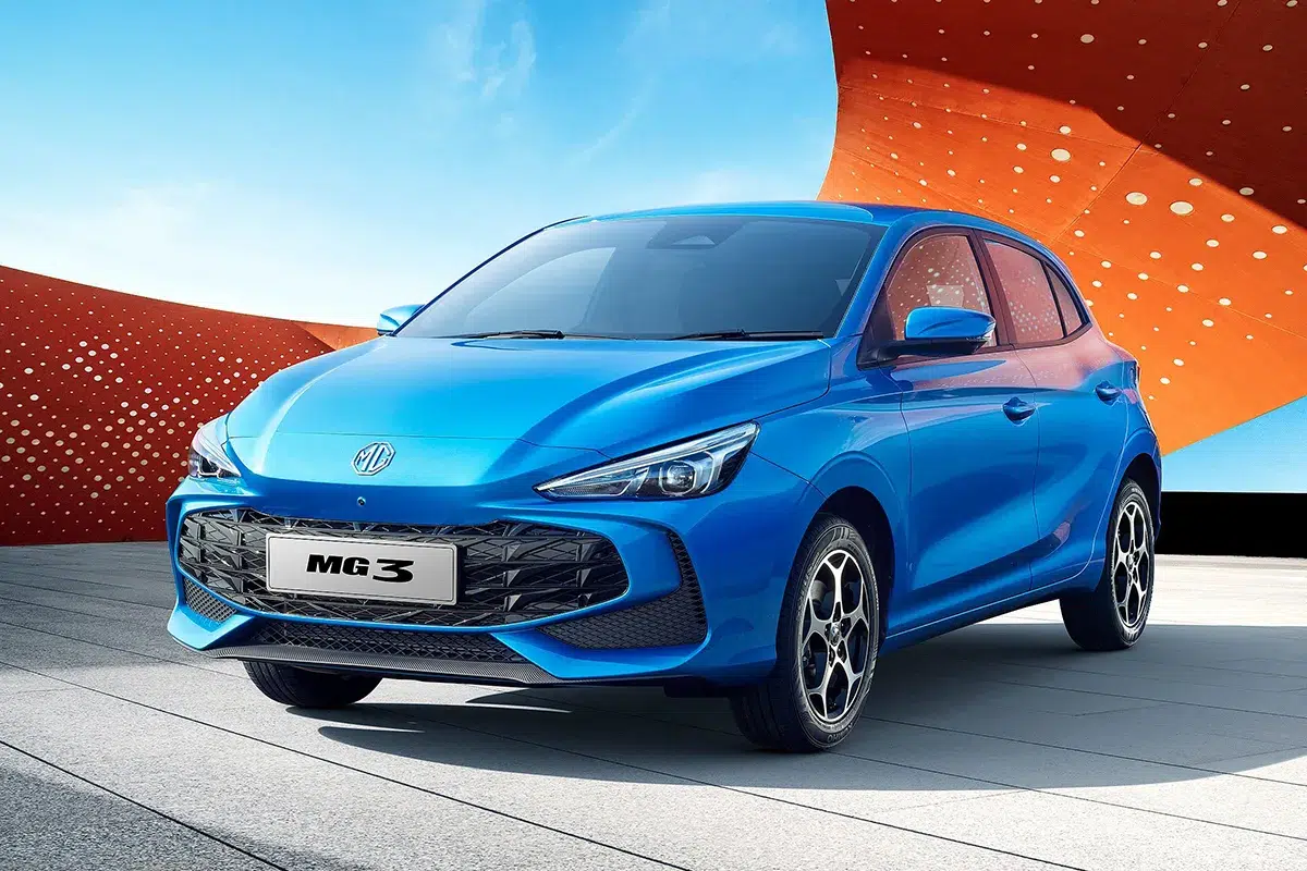 Front three-quarter studio shot of a blue 2026 MG3 hatchback against a red and blue backdrop