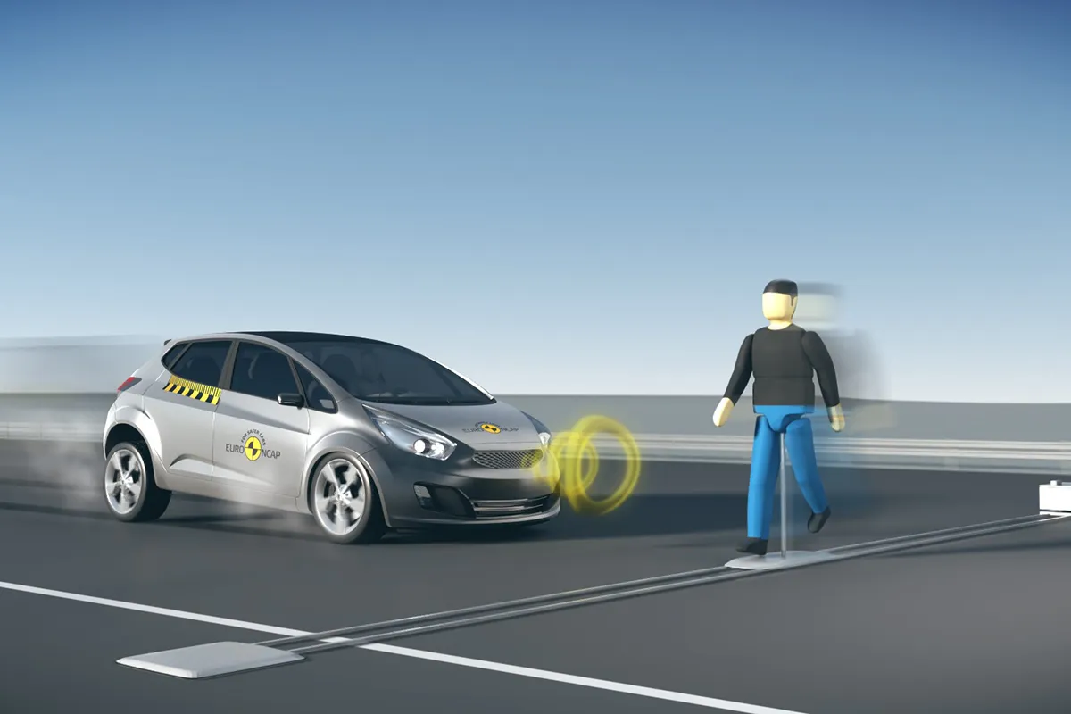 Euro NCAP demonstration of autonomous emergency braking detecting a pedestrian crossing in front of a hatchback, illustrating the AEB technology mandated under ADR 98/00 in Australia