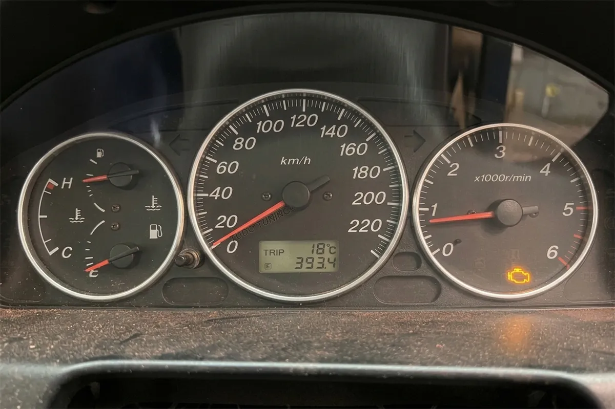 Illuminated check engine light on a Mazda instrument cluster indicating a possible MAF sensor fault