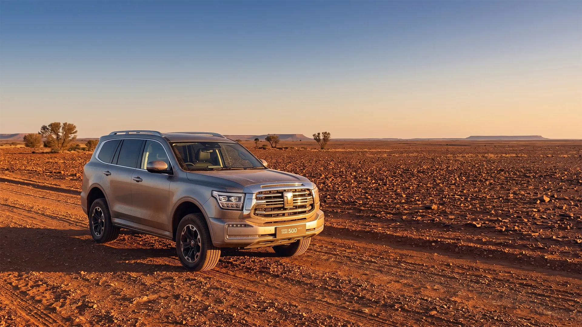 oodnadatta-track-hybrid-suv-gwm-tank-500-phev Silver GWM Tank 500 PHEV parked on the red gibber plains of the Oodnadatta Track at sunset
