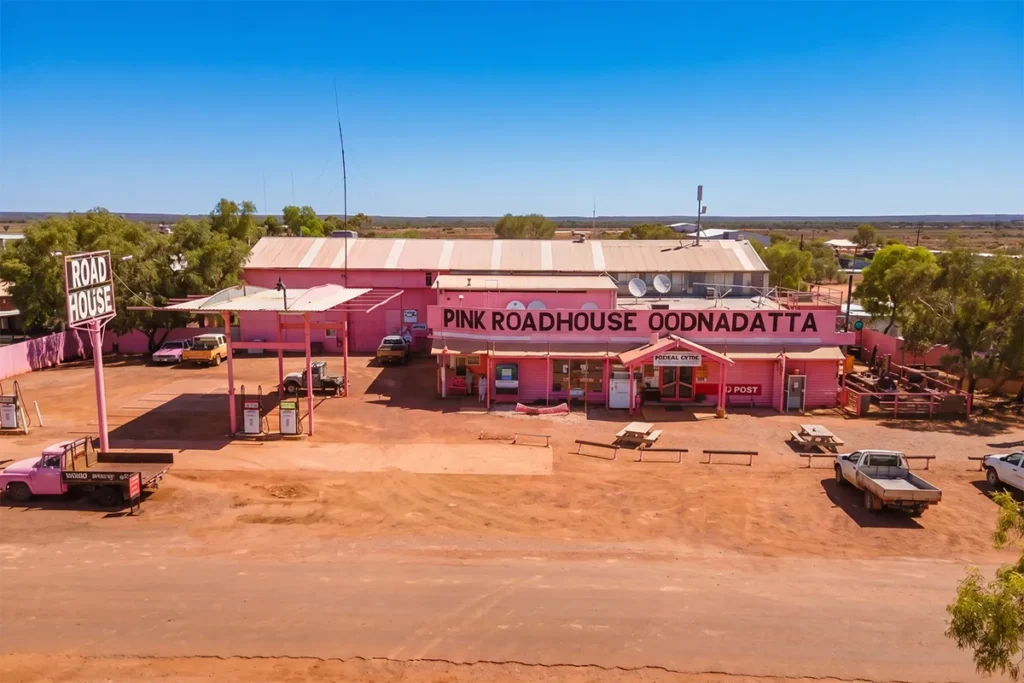 The iconic Pink Roadhouse at Oodnadatta with fuel bowsers and red dirt forecourt
