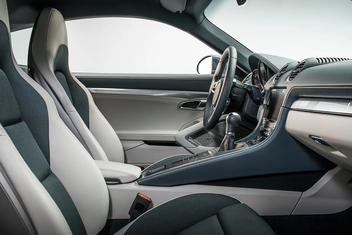 Side interior view of the 2026 Porsche 718 Cayman showing the manual gear shifter and seats