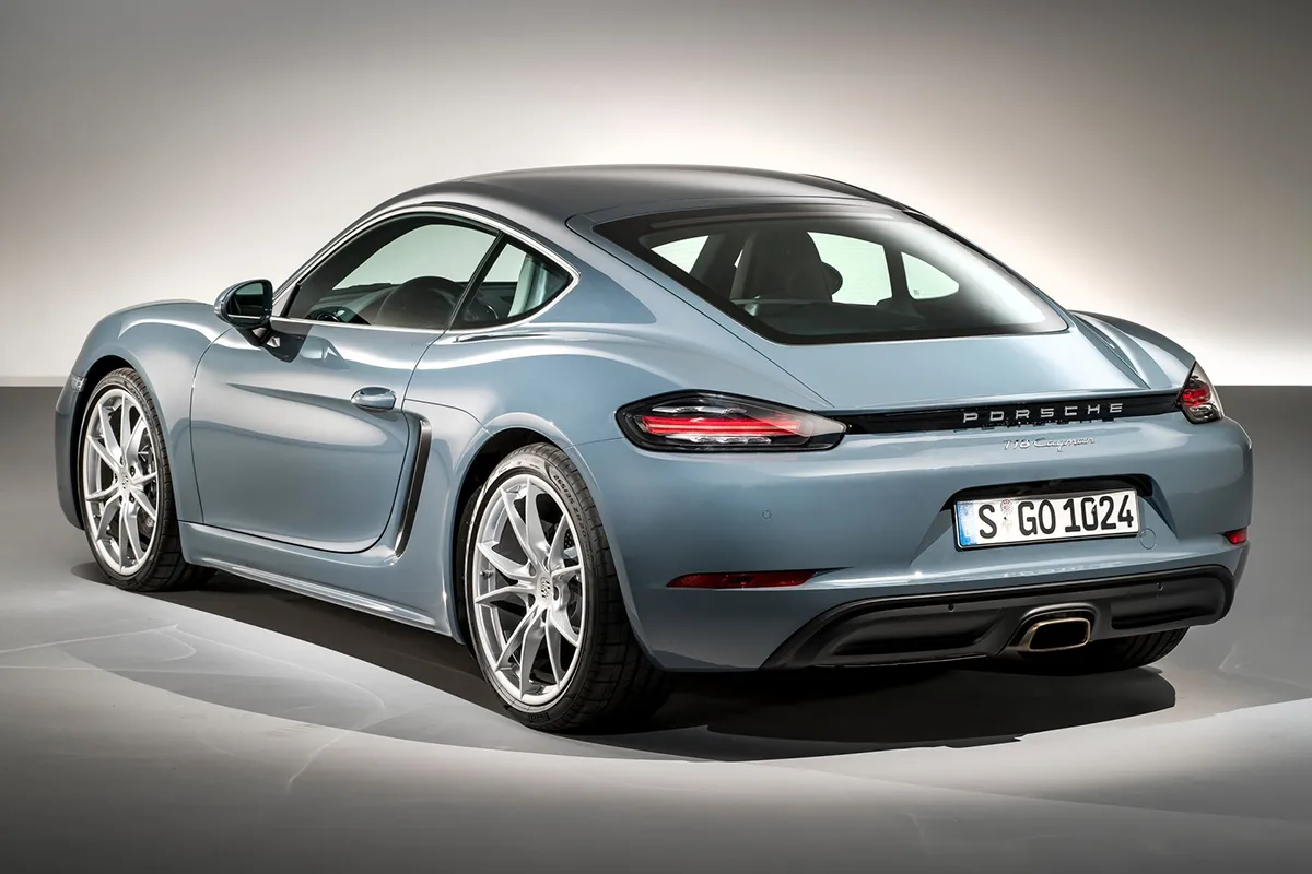 Rear three-quarter studio view of the 2026 Porsche 718 Cayman showing the full-width light bar and silhouette