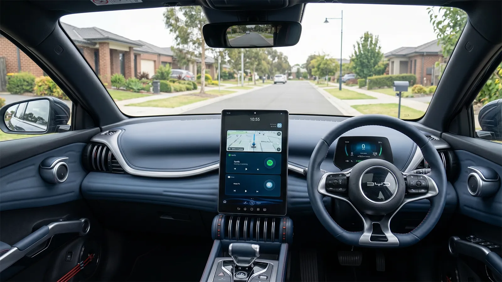 BYD Atto 3 dashboard showing the rotating central touchscreen in landscape mode with maps and Spotify, plus the driver's digital display