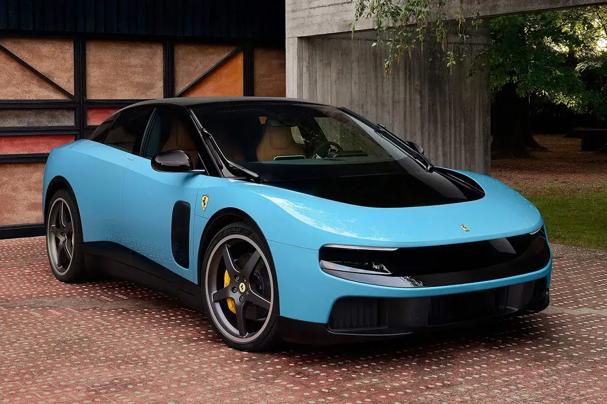 ferrari-luce-blue-front-three-quarter Ferrari Luce in light blue, front three-quarter view, parked on brick courtyard against concrete and greenery