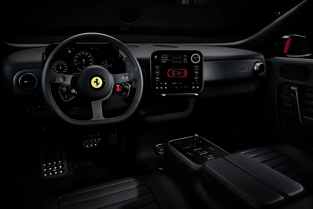 Ferrari Luce black interior from driver perspective showing steering wheel, instrument binnacle, central OLED screen and physical controls