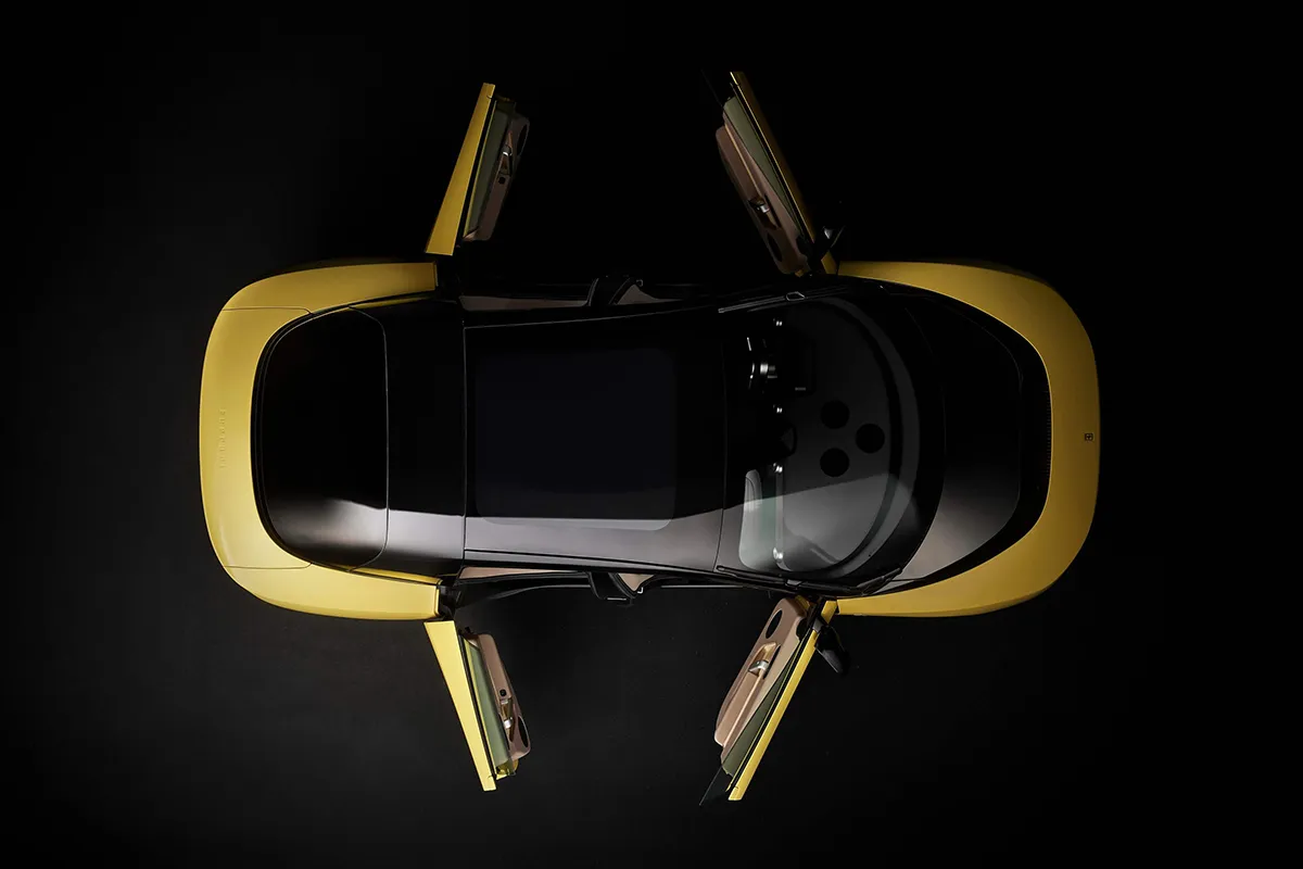 Ferrari Luce in yellow from directly above with all four coach doors open showing the full cabin and door hinge mechanism