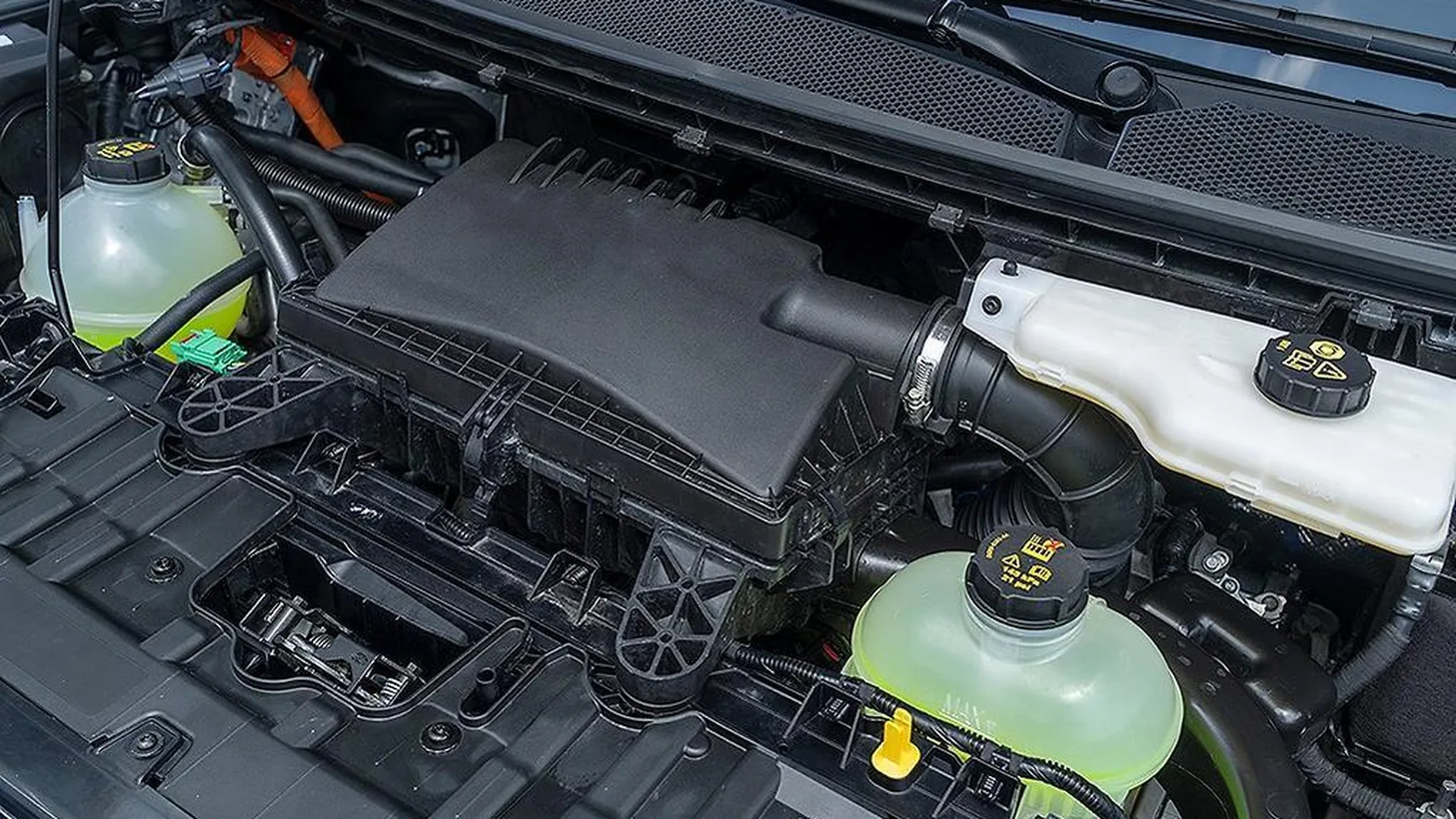 Open engine bay of a Ford Transit Custom showing the airbox, intake plumbing and coolant reservoirs