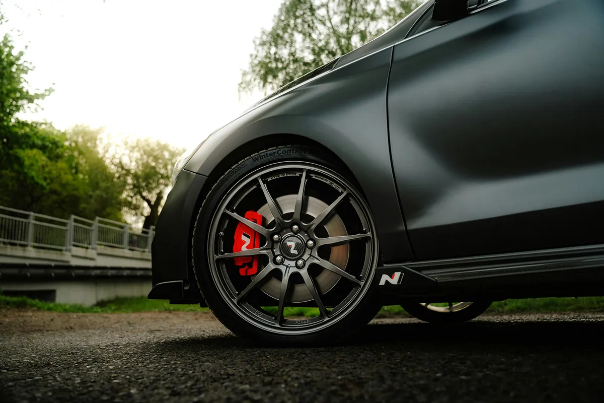 Front wheel and red N-branded brake caliper of a matte grey Hyundai i30 N, the hot hatch that exceeds the 130kW per tonne limit