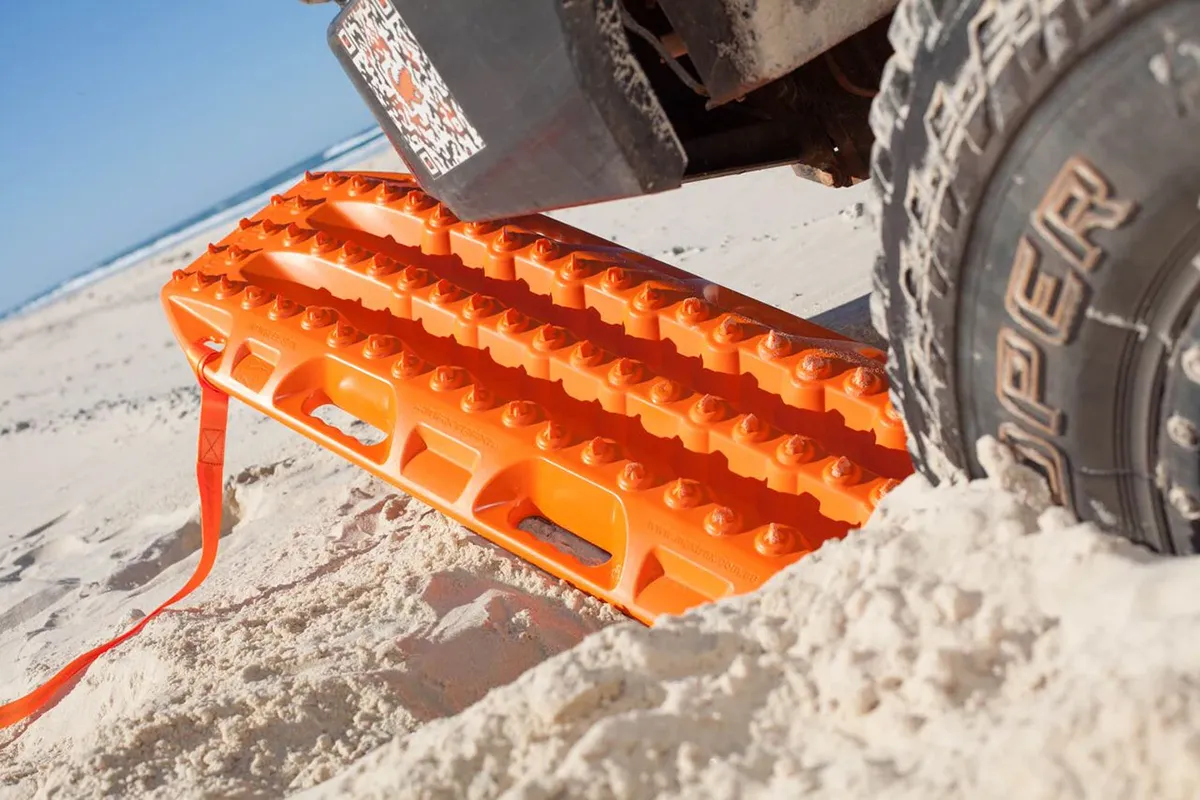 Maxtrax MkII recovery board under a 4WD tyre in soft beach sand