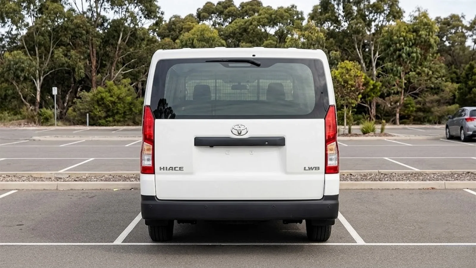 Rear of a white Toyota HiAce LWB van showing the lift-up tailgate, rear wiper and HIACE LWB badging