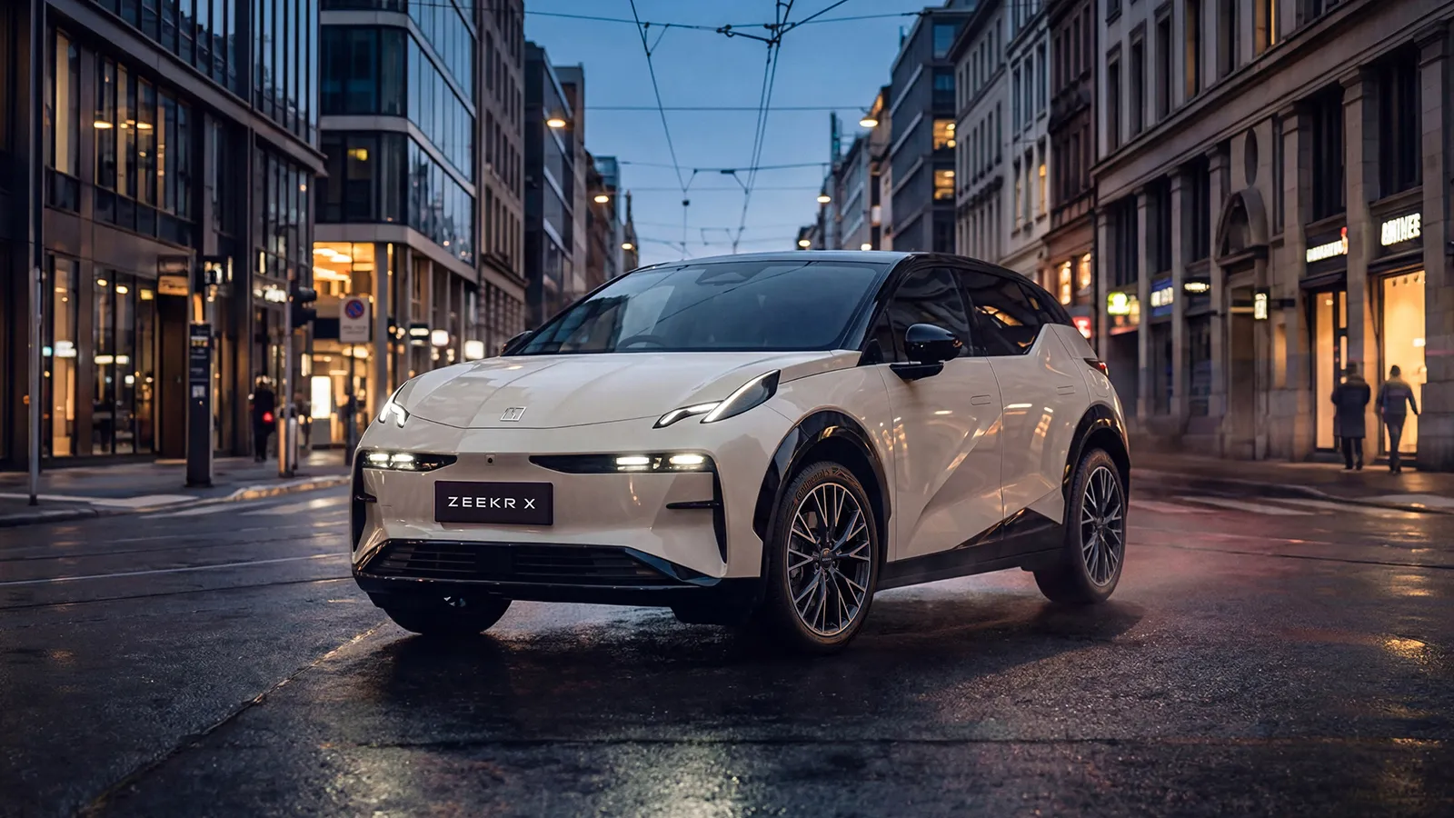 White Zeekr X RWD on a wet urban street at dusk with headlights illuminated, front three-quarter view