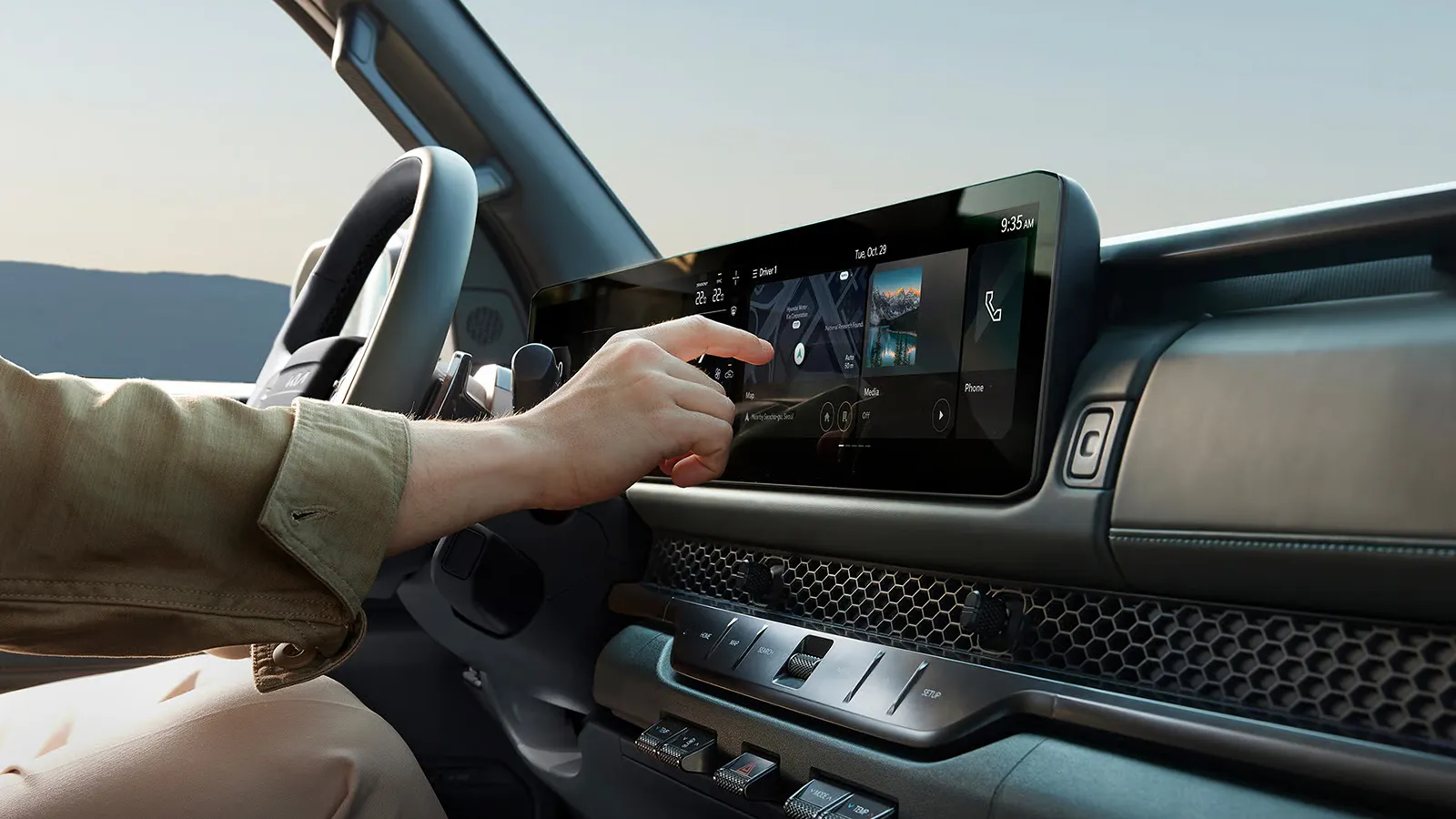 Driver touching the Kia Tasman X-Pro's 12.3-inch infotainment touchscreen