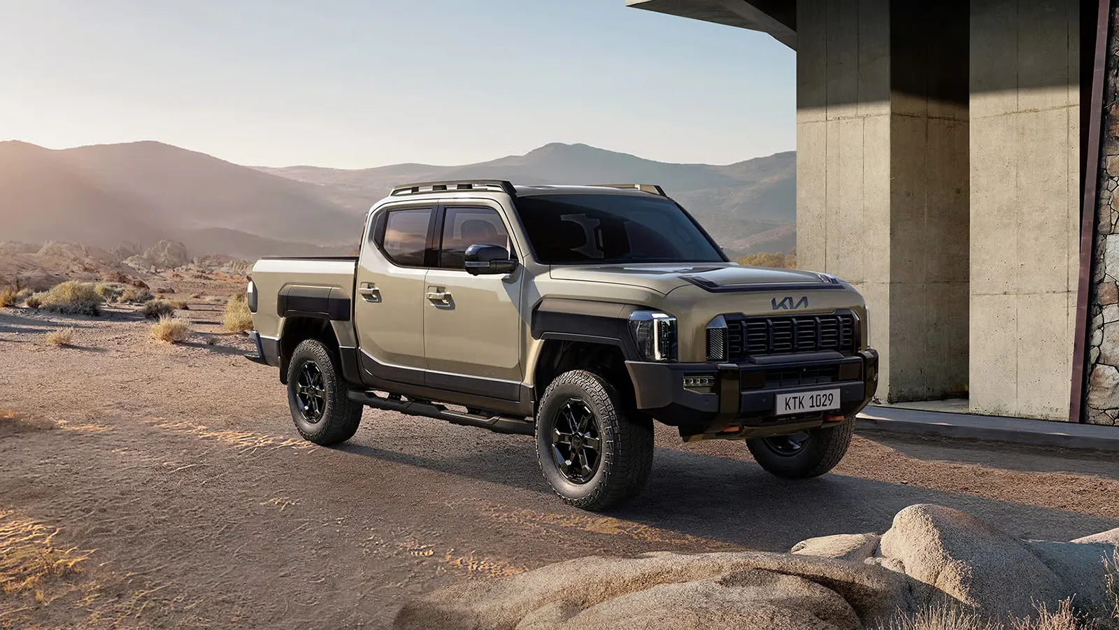 Kia Tasman X-Pro front three-quarter angle parked outside a modern desert building