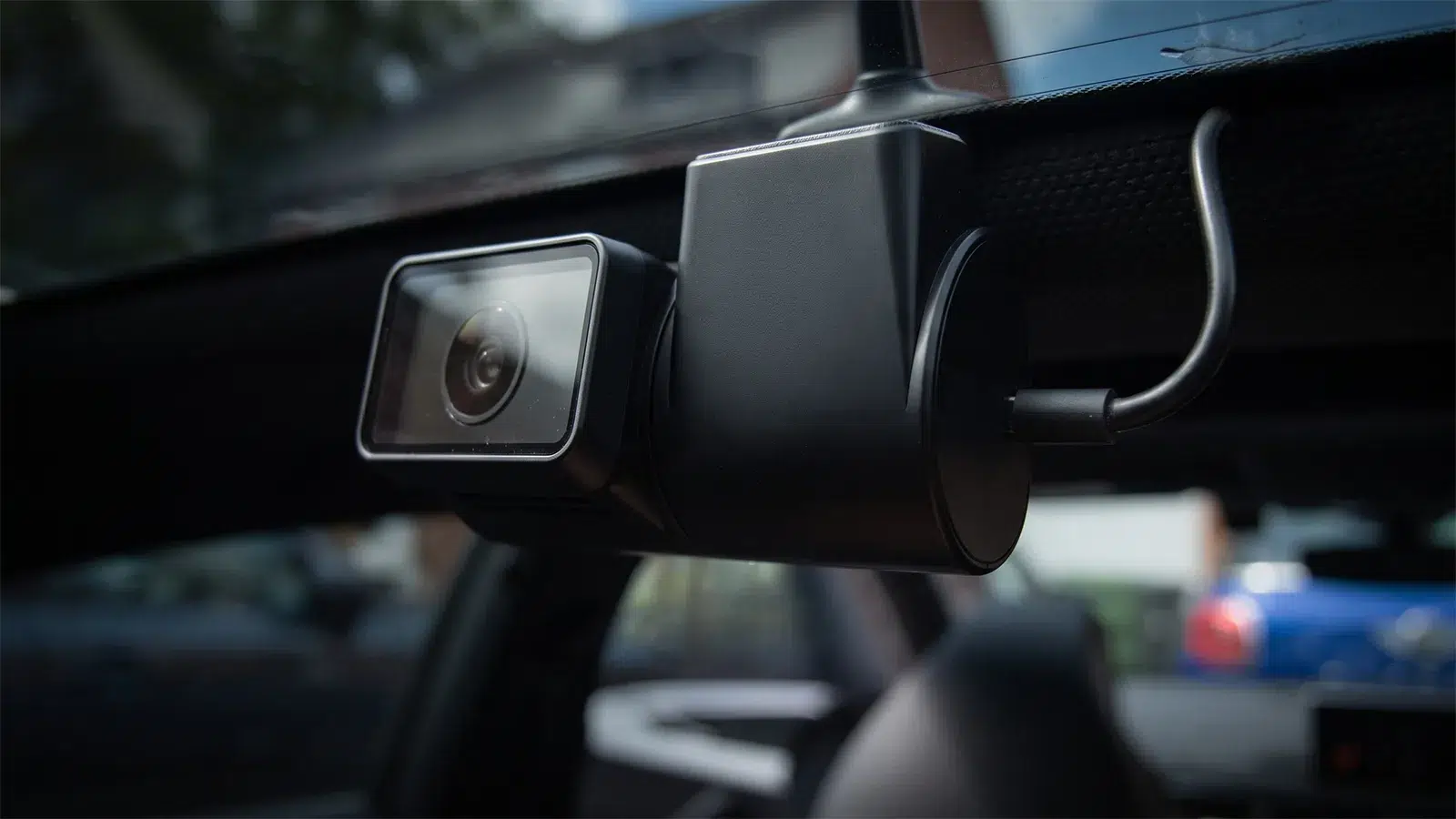 Close-up of a VIOFO A329 camera lens mounted at the top of a car windscreen behind the mirror