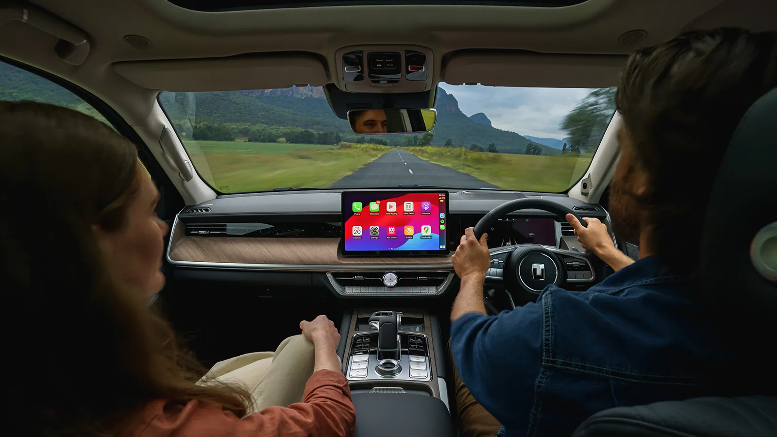 GWM Tank 500 cabin view from the rear seat showing the driver, CarPlay screen and open road ahead