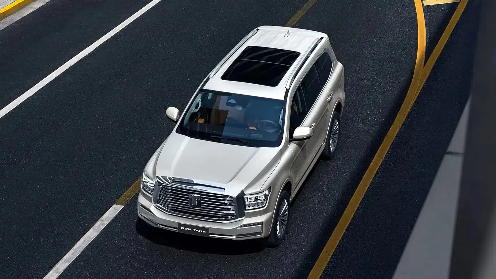 Aerial view of a GWM Tank 500 driving through an urban street with sunroof open