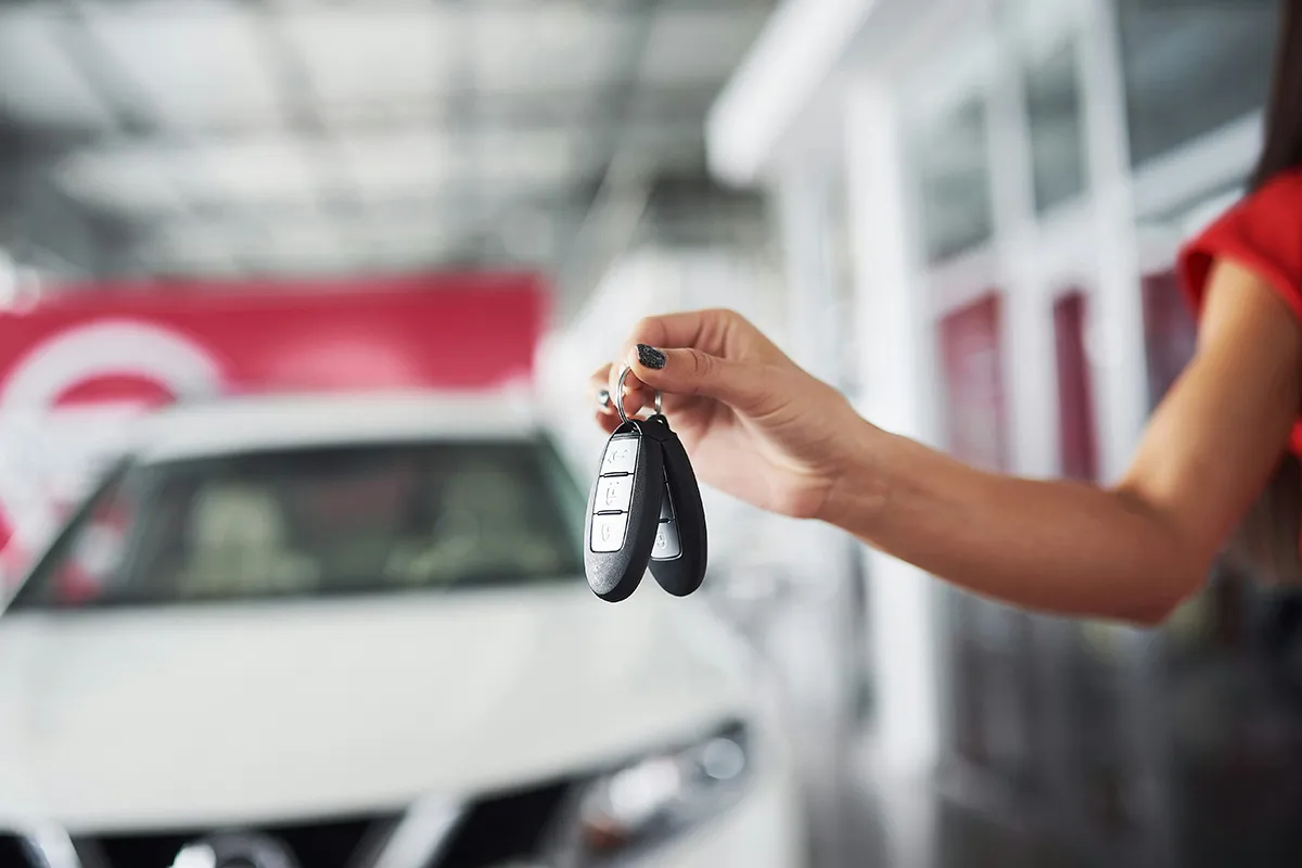 Car keys being handed over at a dealership, new car purchase