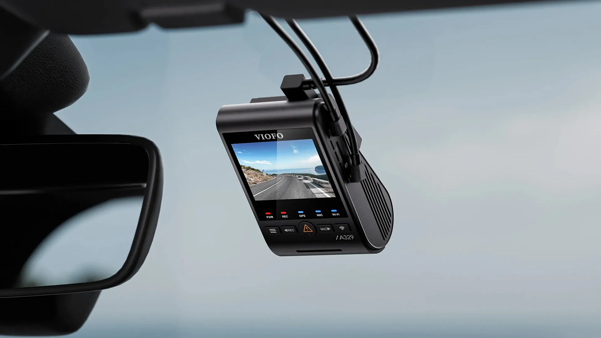 VIOFO A329 dash cam mounted behind the rear-view mirror, its 2-inch screen showing a coastal road and status LEDs