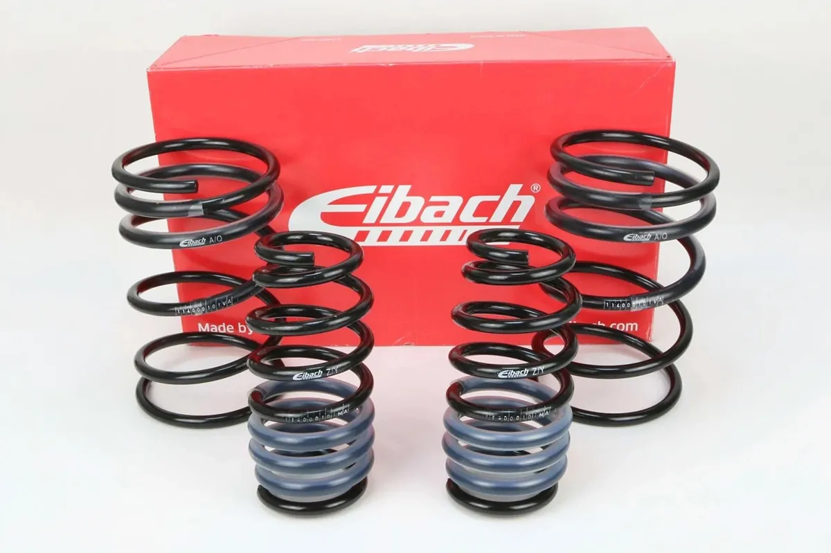 Set of four Eibach lowering springs standing in front of a red Eibach box on a white background