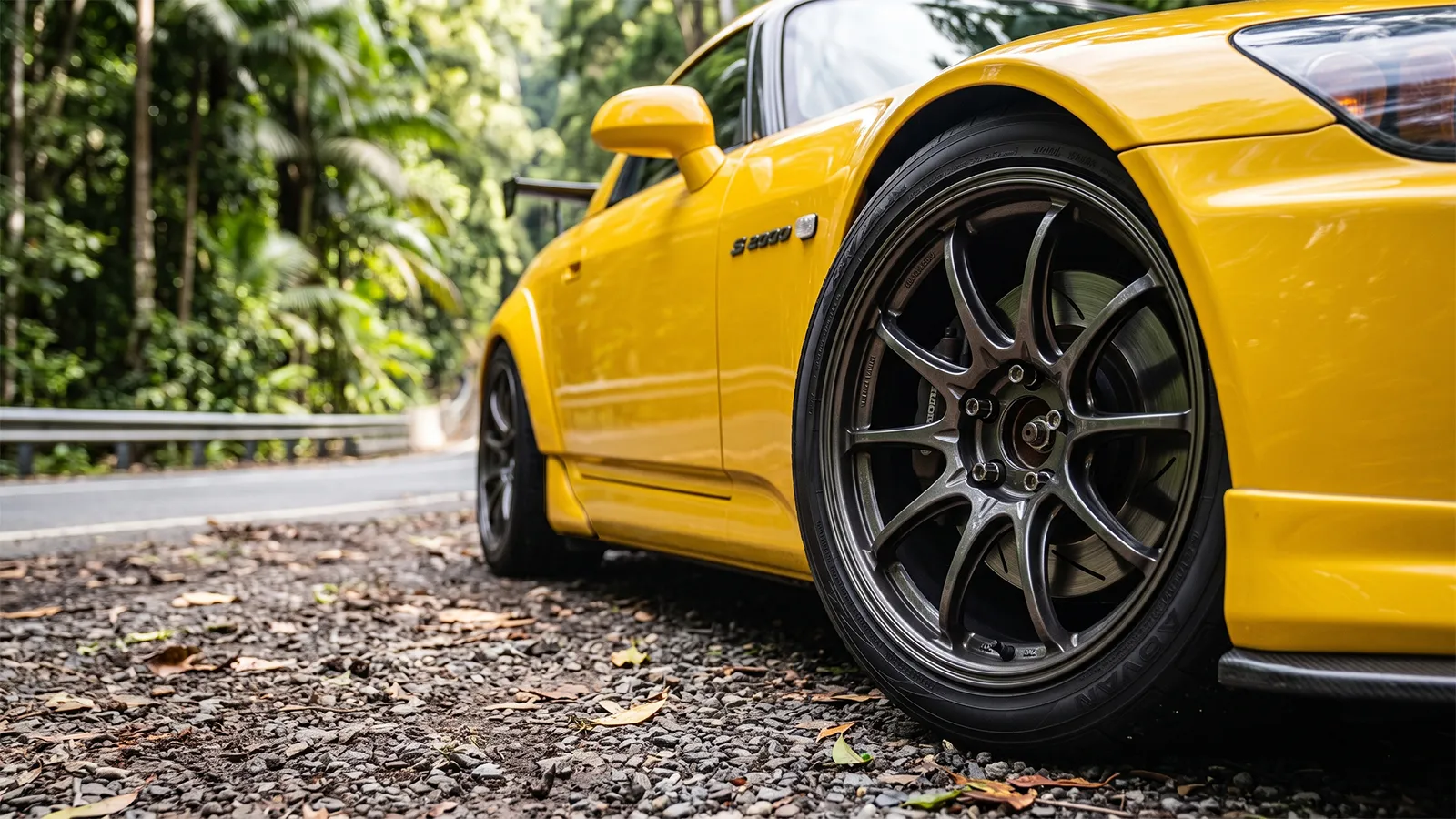 Close-up of a yellow Honda S2000 front wheel showing Advan tyre, alloy spokes and brake disc