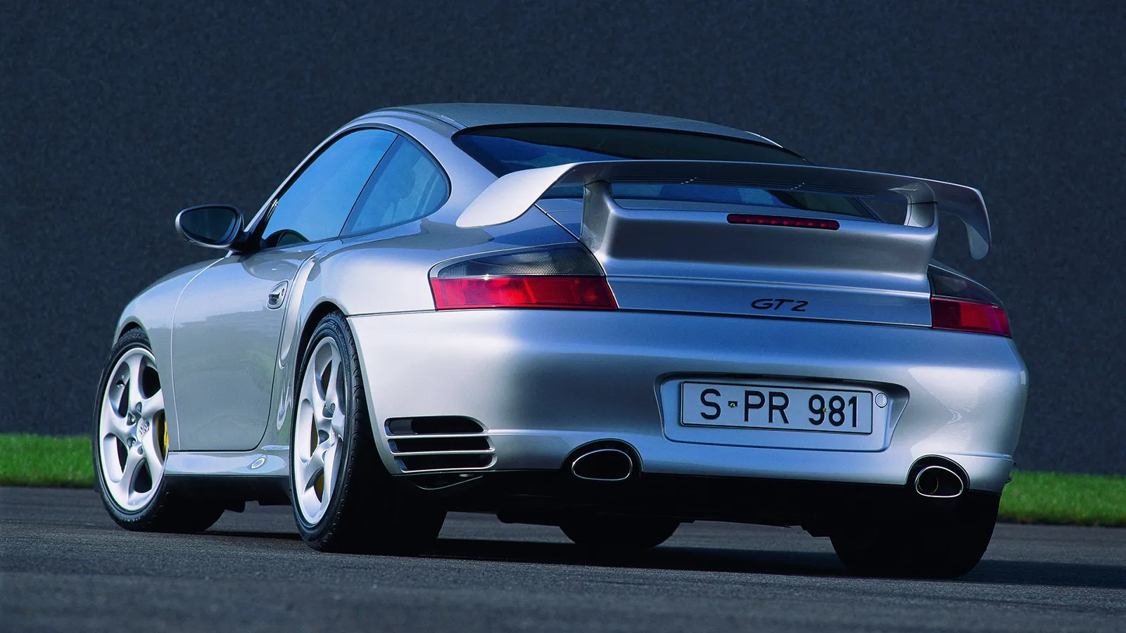 Silver Porsche 911 996 GT2 rear three-quarter view showing the GT2 badge and fixed rear wing