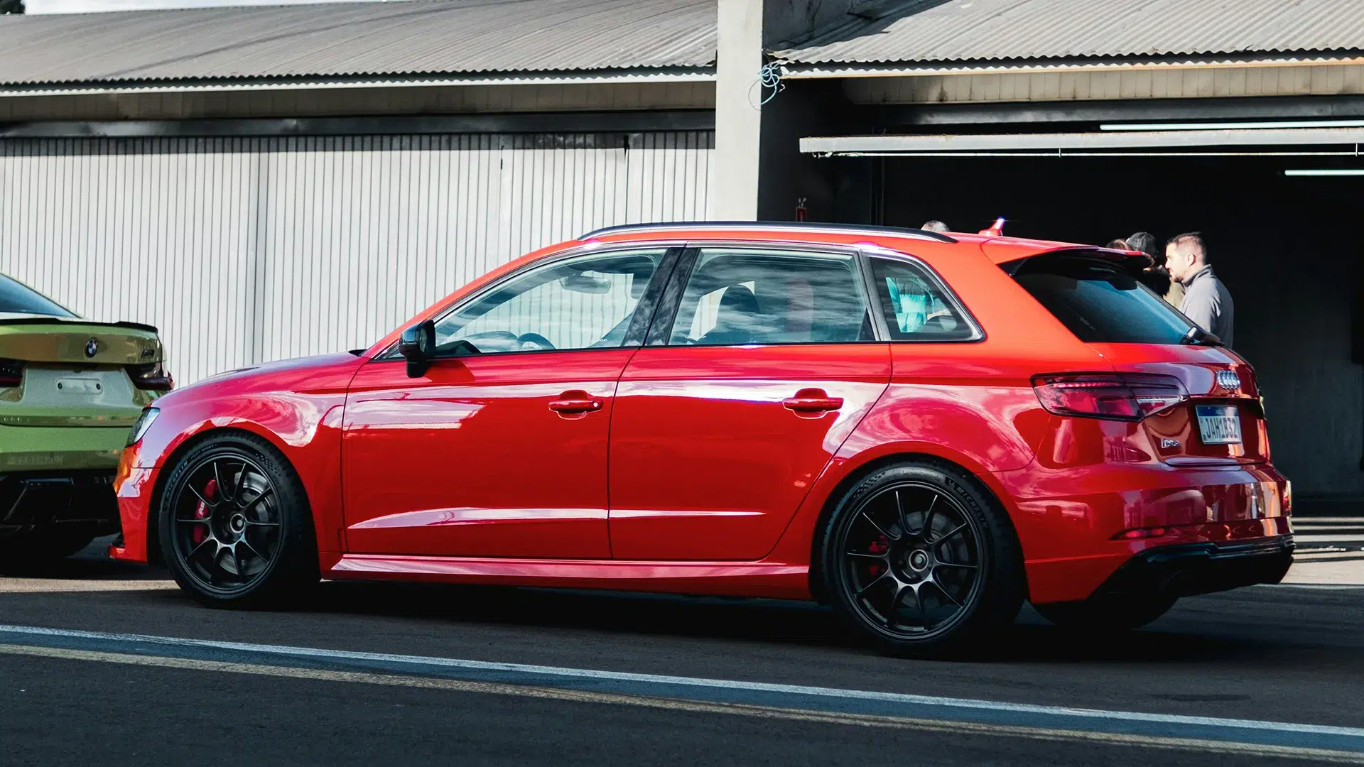 Red Audi RS3 Sportback with black alloy wheels and red brake calipers parked at a car meet