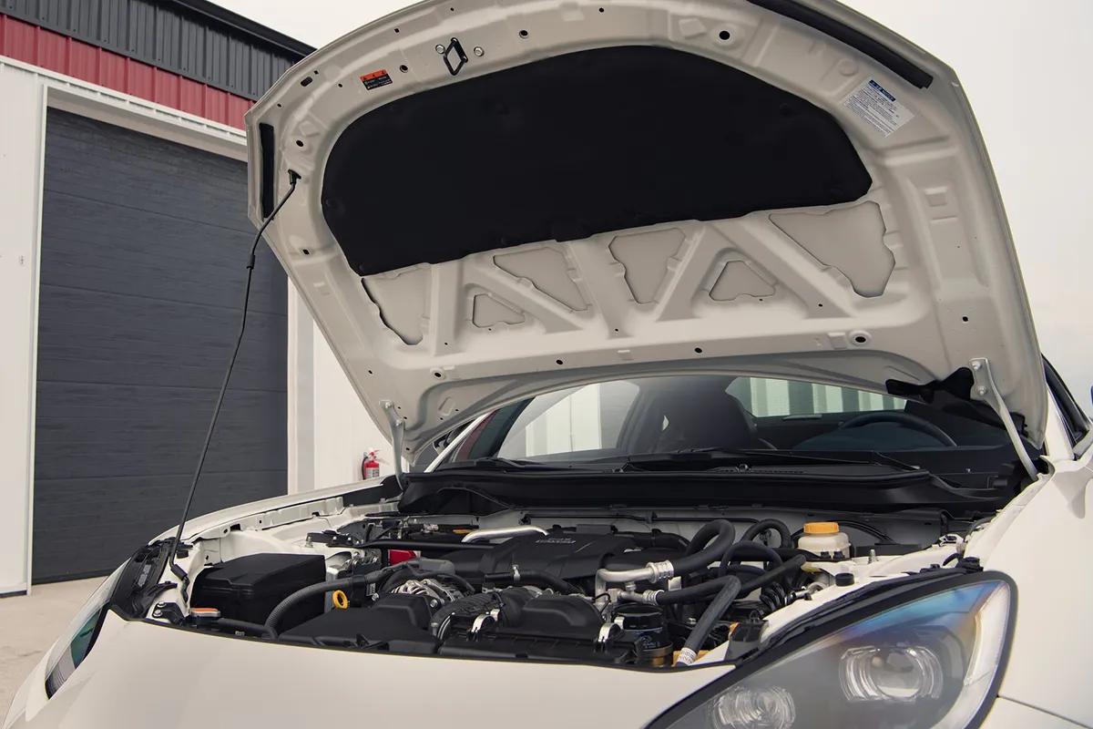 Toyota GR86 with the bonnet raised showing the engine bay from the front of the car