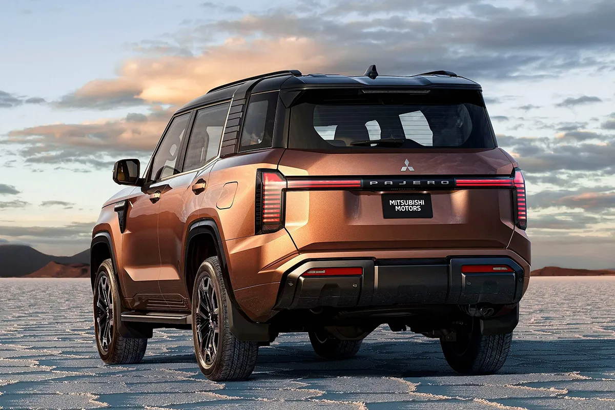 New Mitsubishi Pajero rear three-quarter view on a salt flat at dusk, showing the Pajero badge and tailgate