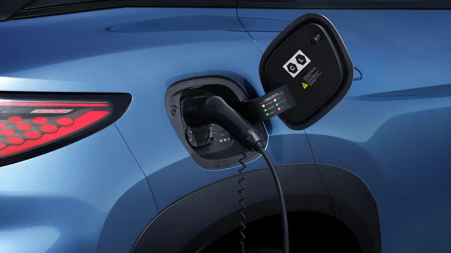 Close-up of a charging cable plugged into the rear charge port of a blue BYD Sealion 7