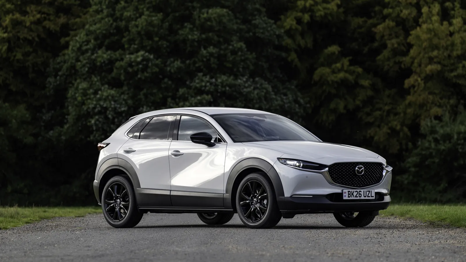 White Mazda CX-30 small SUV parked on a country road, front three-quarter view