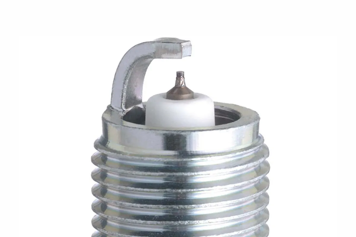 Close-up of a spark plug tip showing the electrode gap between the fine centre electrode and curved ground strap