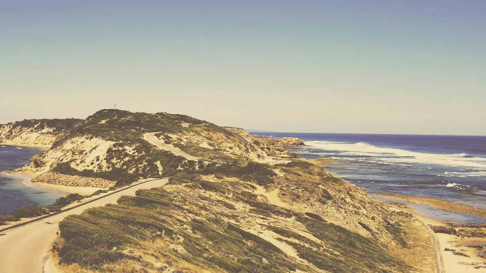 Road winding through sand dunes and coastal scrub toward Fort Nepean at Point Nepean