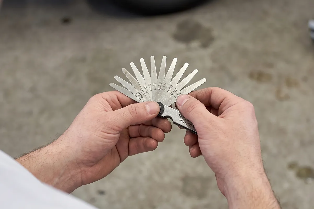 A fanned set of feeler gauge blades used to check spark plug gap without touching the fine centre electrode