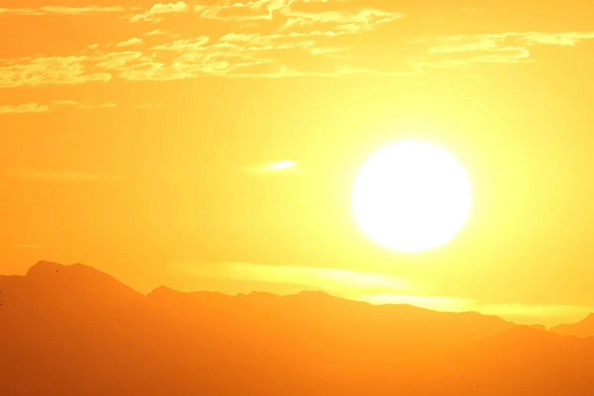 Blazing sun over a mountain range on a hot summer day, when car air conditioning is pushed hardest