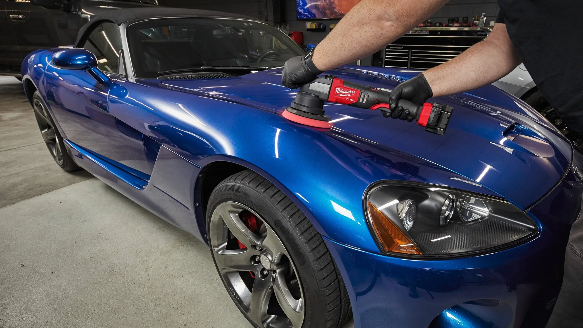 Polishing a blue bonnet with a cordless DA polisher Detailer polishing the bonnet of a glossy blue sports car with a Milwaukee M18 FUEL cordless random orbital polisher