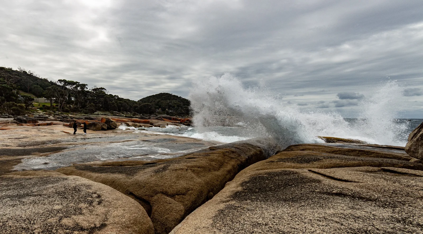 Waves sending spray up through the granite rocks at the Bicheno Blowhole on Tasmania's east coast