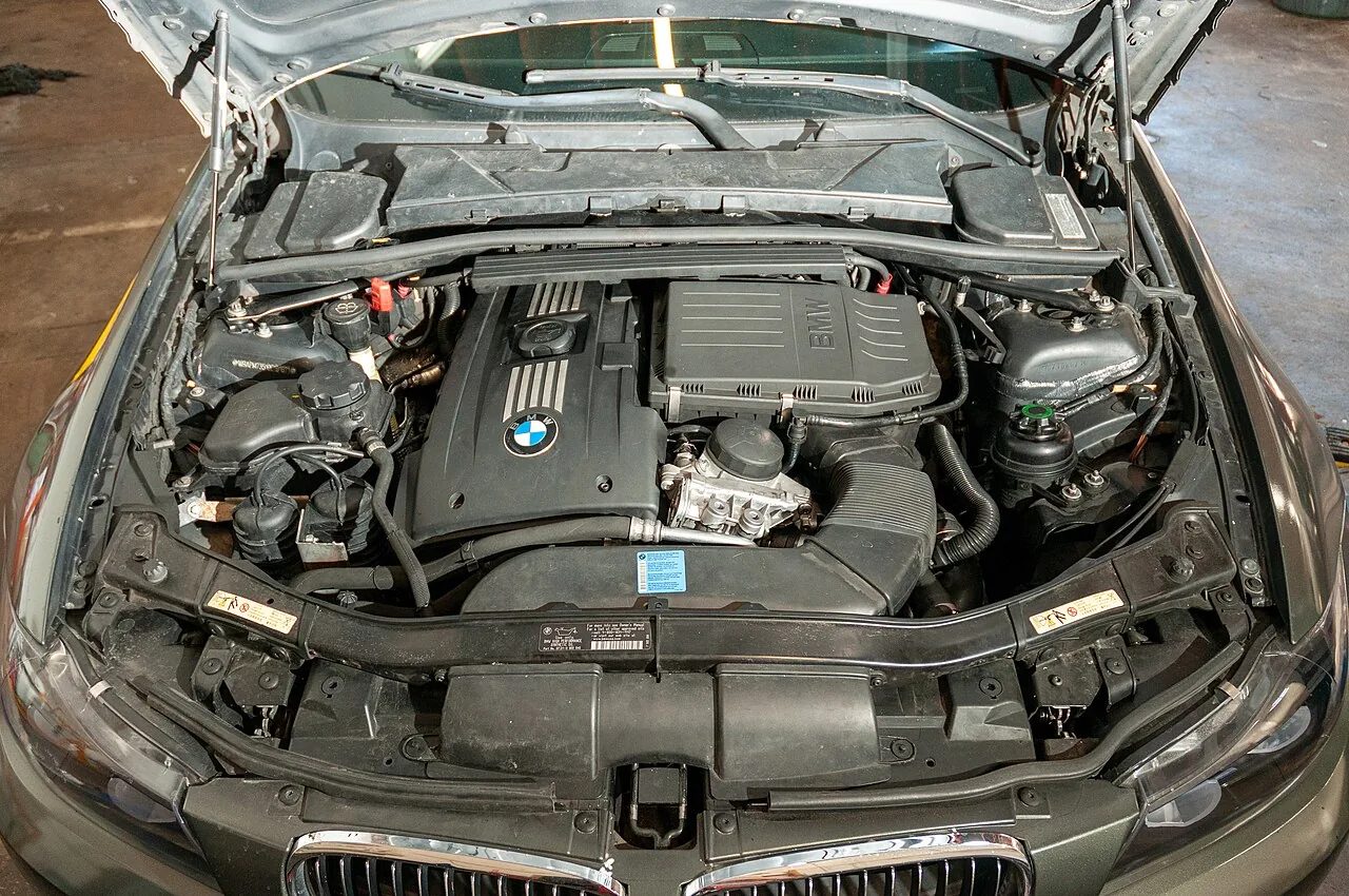 Open bonnet showing the twin-turbo inline-six engine bay of an E90 BMW 335i