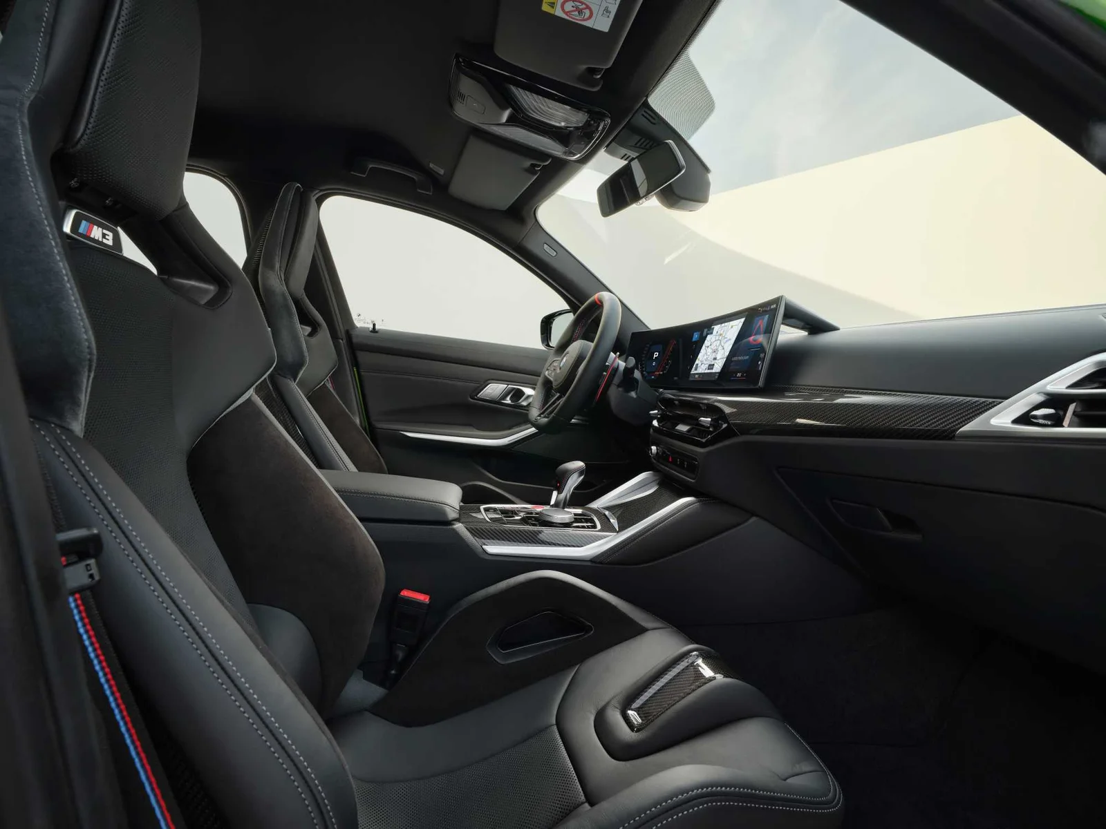 Optional M Carbon bucket seats in the 2025 BMW M3 Competition with the curved display behind them