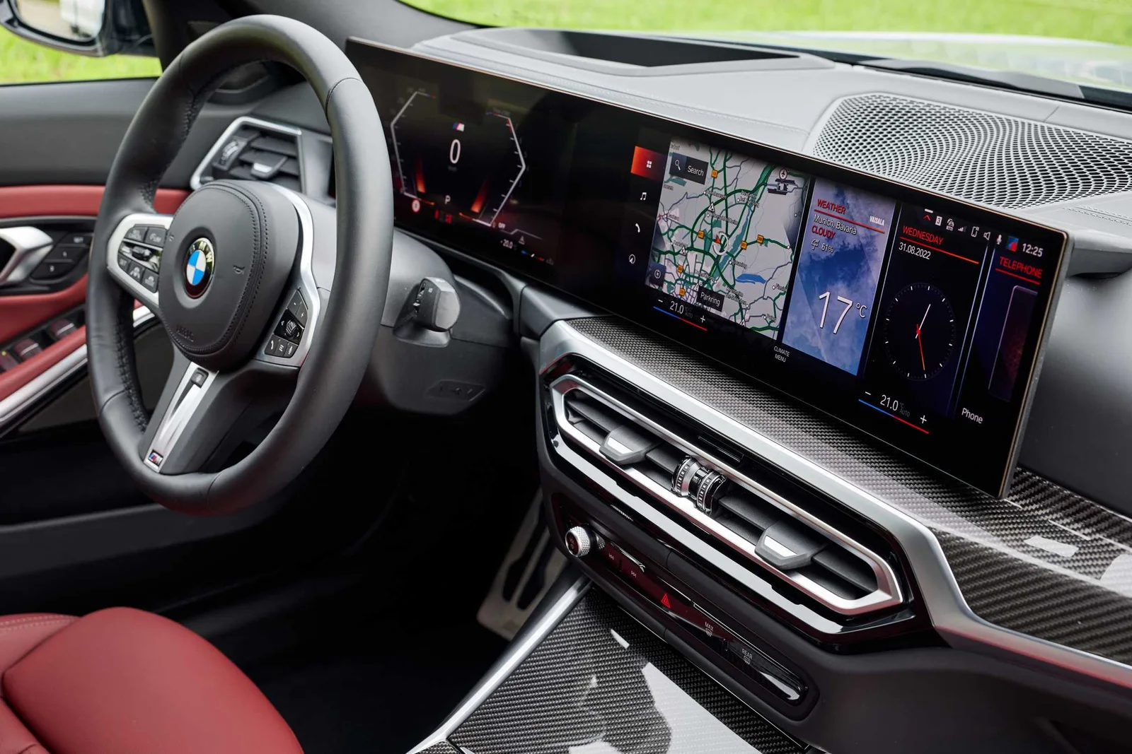 BMW M340i xDrive dashboard with the curved instrument and touchscreen display, M steering wheel and red leather