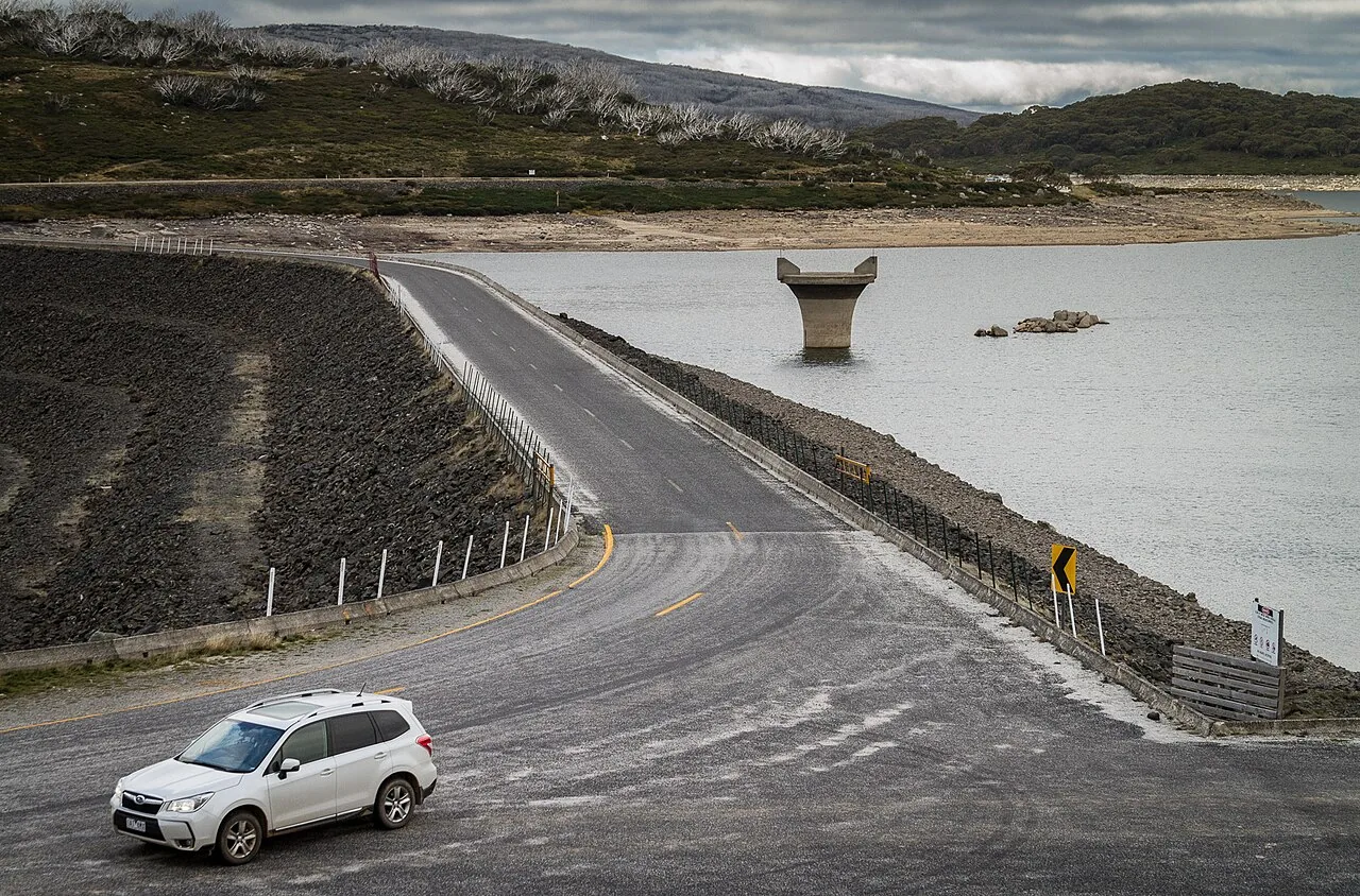 Bogong High Plains Road crossing the Rocky Valley Dam wall near Falls Creek with an SUV on the road