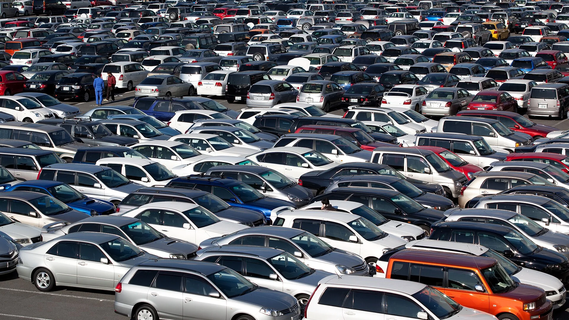 Rows of cars at a wholesale car auction yard Hundreds of used cars parked in tight rows at a large wholesale car auction yard in Japan